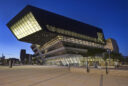 Exterior view at dusk of the Library and Learning center at WU, Vienna by Zaha Hadid